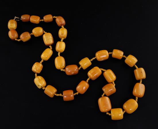 A single strand barrel shaped amber bead necklace, 86cm.